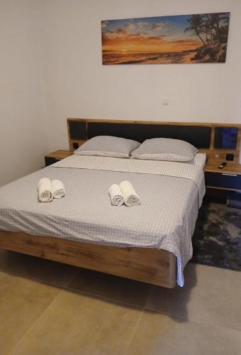 a bedroom with a bed with two slippers on it at sunny holiday in Vinišće