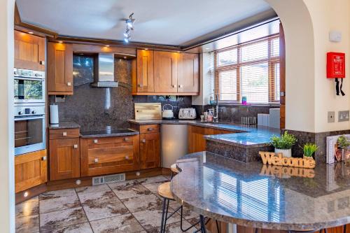 a large kitchen with wooden cabinets and a table at Abbey Farm House - Pet Friendly in Ormskirk