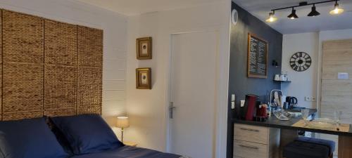 a bedroom with a bed and a desk in a room at Le TOURNY-Studio cosy avec ascenseur- Sarlat - Coeur cité médiévale in Sarlat-la-Canéda