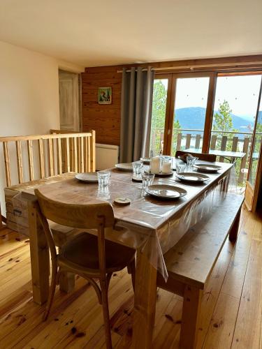 Cette chambre dispose d'une table en bois et d'une grande fenêtre. dans l'établissement Appartement cocooning aux Angles, aux Angles