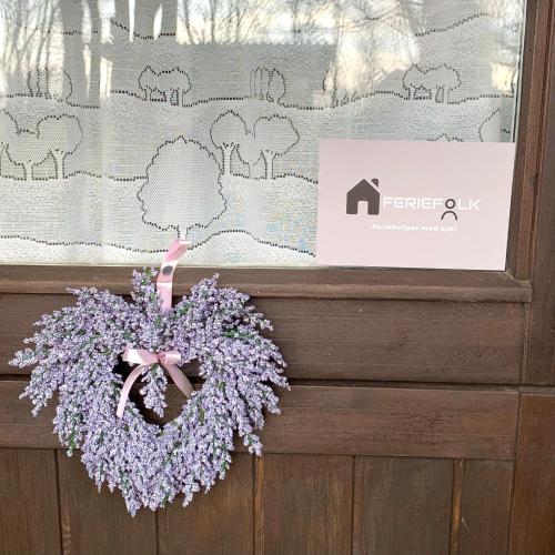 a wreath of lilacs is hanging on a window at FF1001 Sommerhus ved Vesterhavet in Billum