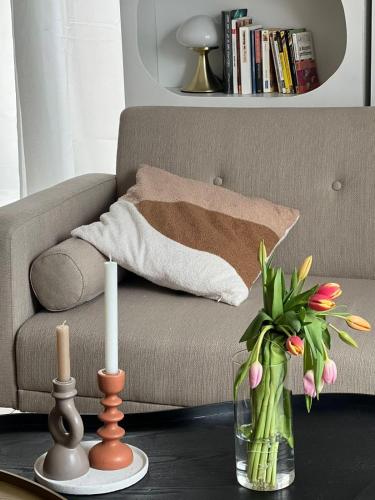 - un salon avec un canapé et un vase de fleurs dans l'établissement Charmant logement - CDG & Astérix, à Vémars