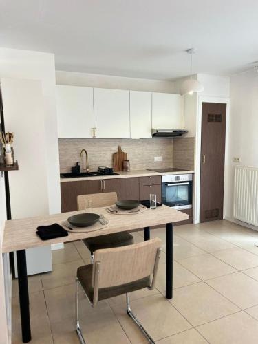 Il comprend une cuisine avec une table et des chaises en bois. dans l'établissement Charmant logement - CDG & Astérix, à Vémars