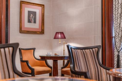 a waiting room with chairs and a table and a lamp at Hôtel Napoleon Paris in Paris