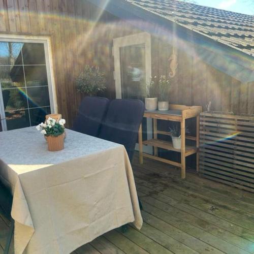 a patio with a table and blue chairs and a desk at FF1001 Sommerhus ved Vesterhavet in Billum