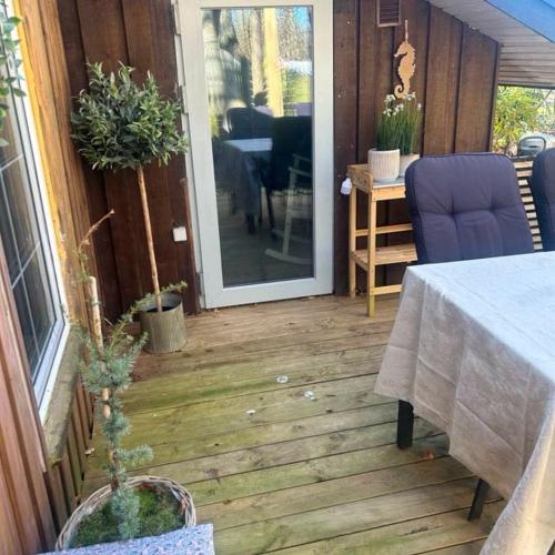 a patio with a table and a glass door at FF1001 Sommerhus ved Vesterhavet in Billum