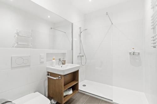 a white bathroom with a sink and a shower at 4 Min to Metro I 12 Min to Inner City I Top Wifi in Vienna