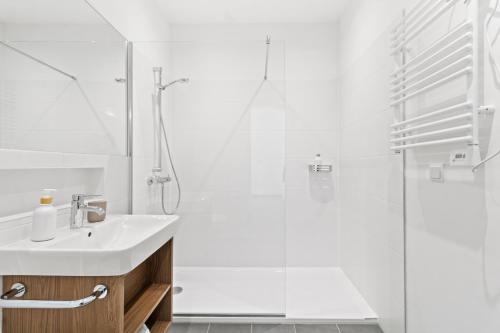 a white bathroom with a sink and a shower at 4 Min to Metro I 12 Min to Inner City I Top Wifi in Vienna