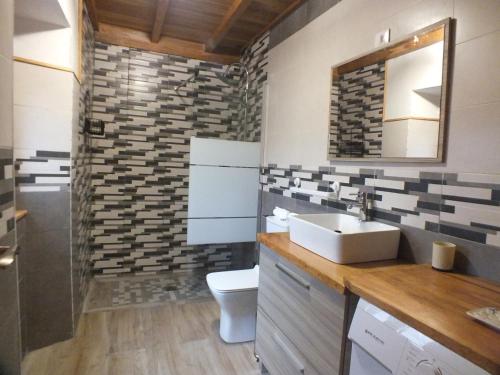 a bathroom with a sink and a toilet and a mirror at Apartamentos Rurales Casa Llucas in San Julián