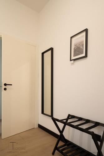 a room with a mirror and a chair next to a door at Turchetti's Rooms in Porto Ercole