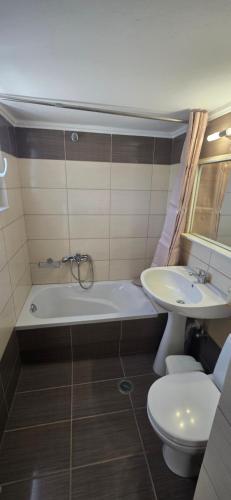 a bathroom with a sink and a tub and a toilet at GLIPTIS Apartments in Karfas
