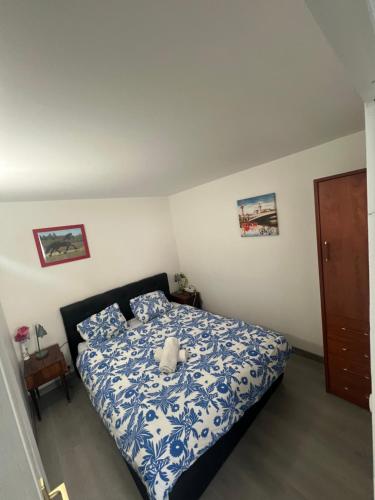 une chambre avec un lit avec une couette bleue et blanche dans l'établissement studio de la gare, à Vesoul