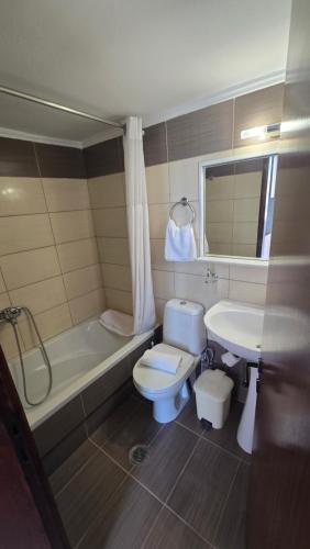 a bathroom with a toilet and a tub and a sink at GLIPTIS Apartments in Karfas