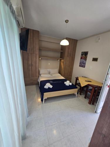 a small bedroom with a bed and a table at GLIPTIS Apartments in Karfas