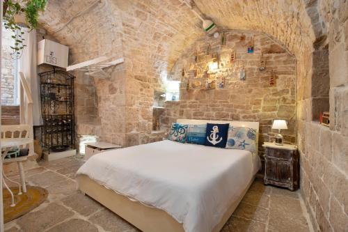 a bedroom with a large bed in a stone wall at La Cantina in Giovinazzo