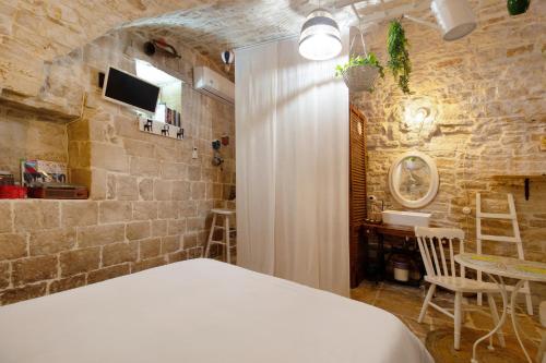 a bedroom with a bed and a stone wall at La Cantina in Giovinazzo