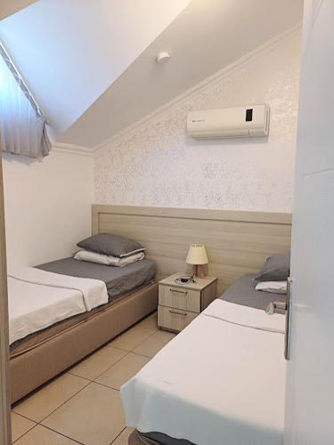 a hotel room with two beds and a heater at Paddys Apartments, Hisarönü in Fethiye