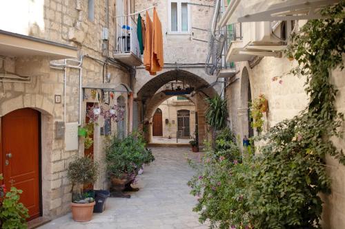 an alley in an old town with plants and flowers at La Cantina in Giovinazzo