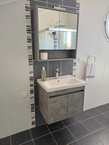 a bathroom with a sink and a mirror at Paddys Apartments, Hisarönü in Fethiye