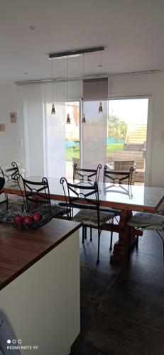 une salle à manger avec une table et des chaises dans une cuisine dans l'établissement Maison Pays des Abers Réservation exclusive à la quinzaine du 9 au 23 août 2025, à Plouguerneau