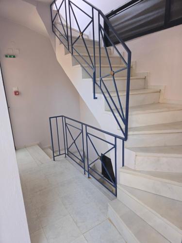 a staircase with blue metal railings in a building at GLIPTIS Apartments in Karfas
