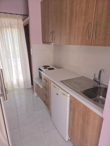 a small kitchen with a sink and a stove at GLIPTIS Apartments in Karfas
