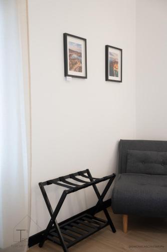 a living room with a couch and two pictures on the wall at Turchetti's Rooms in Porto Ercole