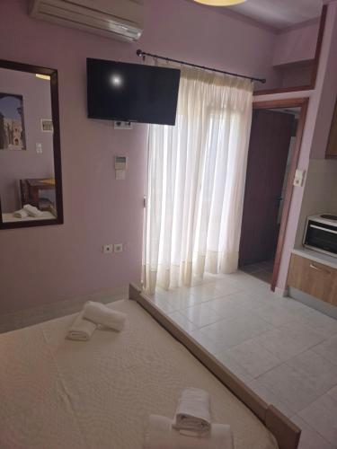 a room with a large window and a flat screen tv at GLIPTIS Apartments in Karfas