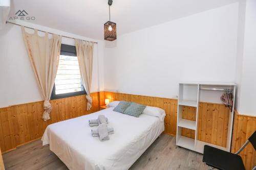 een slaapkamer met een wit bed en een raam bij House Beach Park in La Herradura