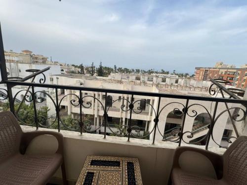 a balcony with chairs and a view of a building at Hurghada Sea View Apartment in Hurghada
