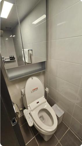 a small bathroom with a toilet and a mirror at Seomyeon MZ Stay in Busan
