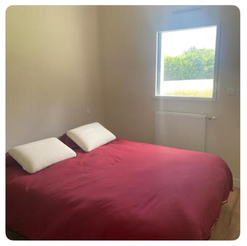 - une chambre avec un lit rouge et une fenêtre dans l'établissement Maison paisible, à Tréméoc