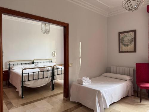 a bedroom with two beds and a mirror at Hotel Parque Balneario Termas Pallares in Alhama de Aragón