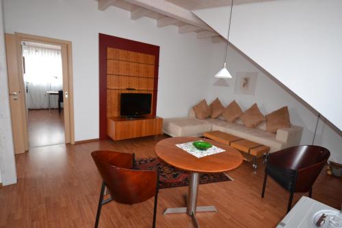 a living room with a table and a couch at Weinhaus Steppe Hotel 3***Superior und Weinstube in Waldbronn