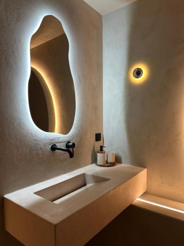 une salle de bain avec un lavabo et un miroir au mur dans l'établissement Maison Paume - Collection AURA - Charleville-Mézières à deux pas de la Place Ducale, à Charleville-Mézières