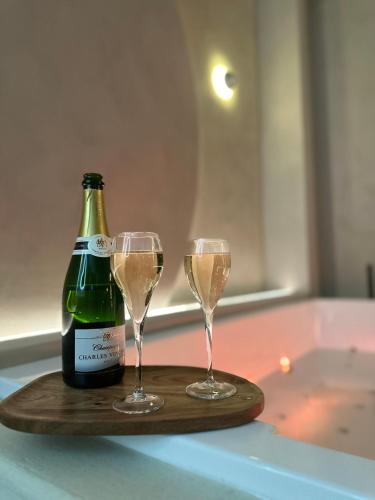 - une bouteille de champagne et deux verres sur un plateau dans l'établissement Maison Paume - Collection AURA - Charleville-Mézières à deux pas de la Place Ducale, à Charleville-Mézières