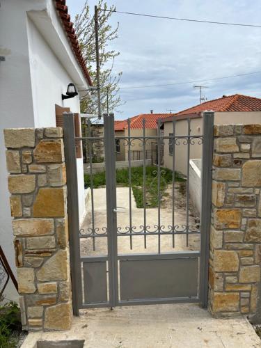 an iron gate with a stone wall at Aegean House in Kymi