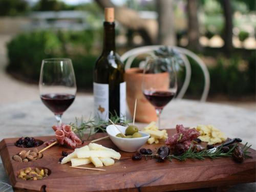 a wooden cutting board with wine glasses and food at Terra Verde in Račički Brijeg
