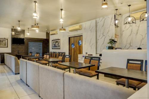 a dining room with tables and chairs in a restaurant at Super Townhouse OAK Regal Inn Near Sant Tukaram Nagar Metro Station in Pune