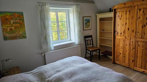 a bedroom with a bed and a window and a chair at FeWo Gisela in Fehmarn