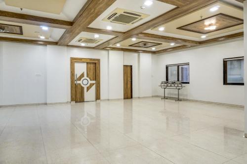 a large room with white walls and a wooden ceiling at Super Townhouse OAK Regal Inn Near Sant Tukaram Nagar Metro Station in Pune