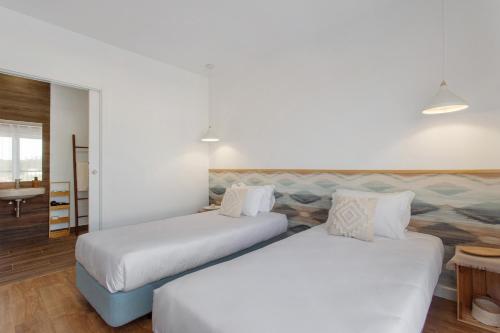 a hotel room with two beds and a table at Quinta dos Raposos- Nazaré Portugal in Nazaré