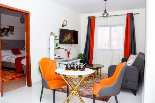 a living room with a table and chairs and a bed at 1 Bedroom Apartment in Syokimau near Airport and SGR in Nairobi