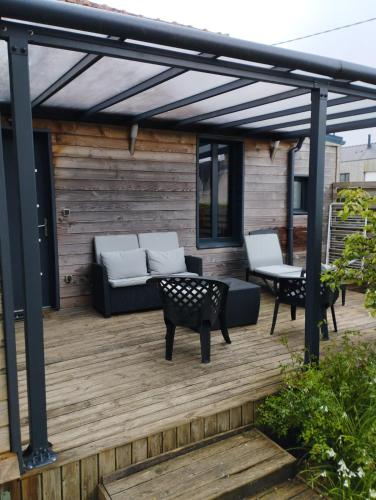 une pergola avec un canapé et une table sur une terrasse dans l'établissement un îlot de calme, à Morlaix