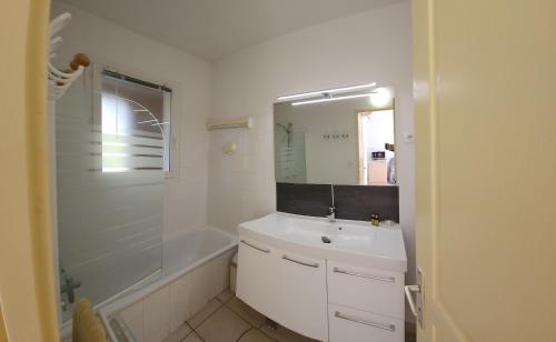 une salle de bain blanche avec un lavabo et une douche dans l'établissement Residence Albizia, à Gréoux-les-Bains