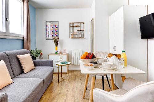 - un salon avec un canapé et une table avec des fruits dans l'établissement Studio Cosy au coeur de Paris pres des Buttes-Chaum, à Paris