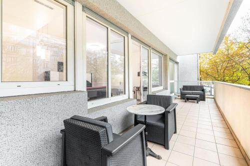 une salle d'attente vide avec des chaises, une table et des fenêtres dans l'établissement GuestReady - Bright charm with a terrace, à Paris