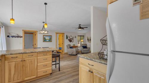 a kitchen with a refrigerator and a dining room at Kinglet - Unit 46 in Sunriver