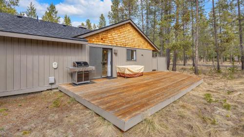 a backyard with a wooden deck next to a house at Kinglet - Unit 46 in Sunriver