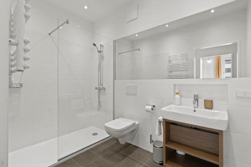 a white bathroom with a shower and a toilet and a sink at 4 Min to Metro I 12 Min to Inner City I Top Wifi in Vienna
